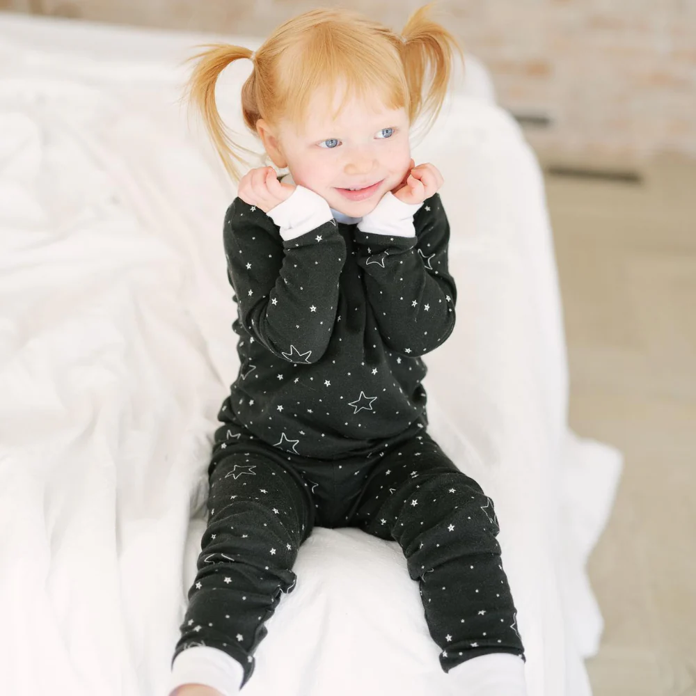 A child wears incontinence pyjamas in black star pattern